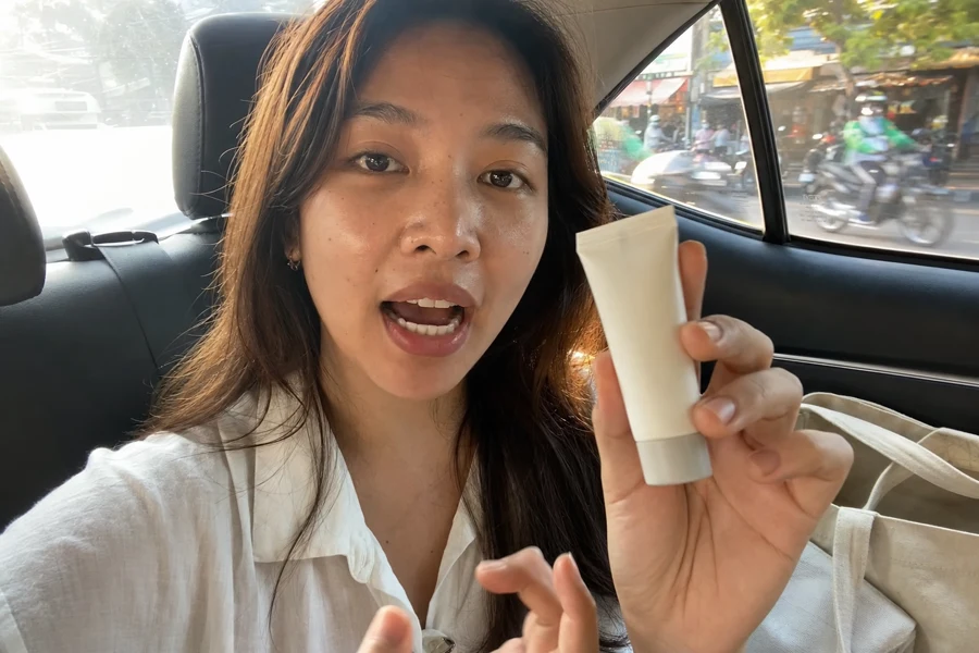 Realistic phone-shot AI UGC product video frame inside a Bangkok taxi